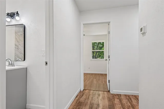 a view of a room with wooden floor and mirror