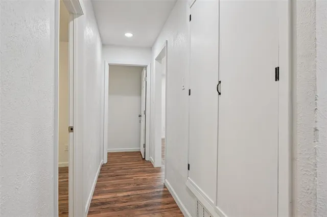 a view of a hallway with wooden floor