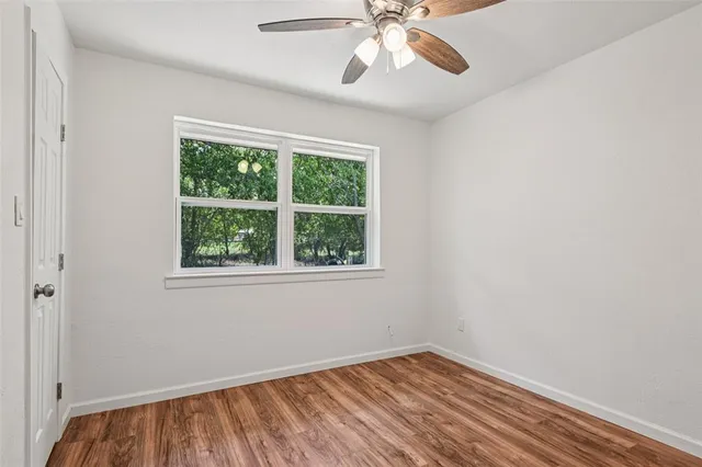 an empty room with a window and wooden floor