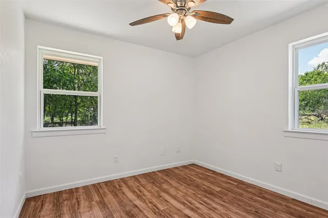 an empty room with a window and wooden floor