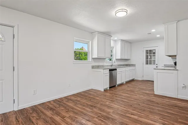 a kitchen with granite countertop white cabinets and white appliances