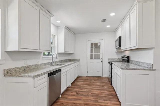 a kitchen with stainless steel appliances granite countertop a sink stove and cabinets