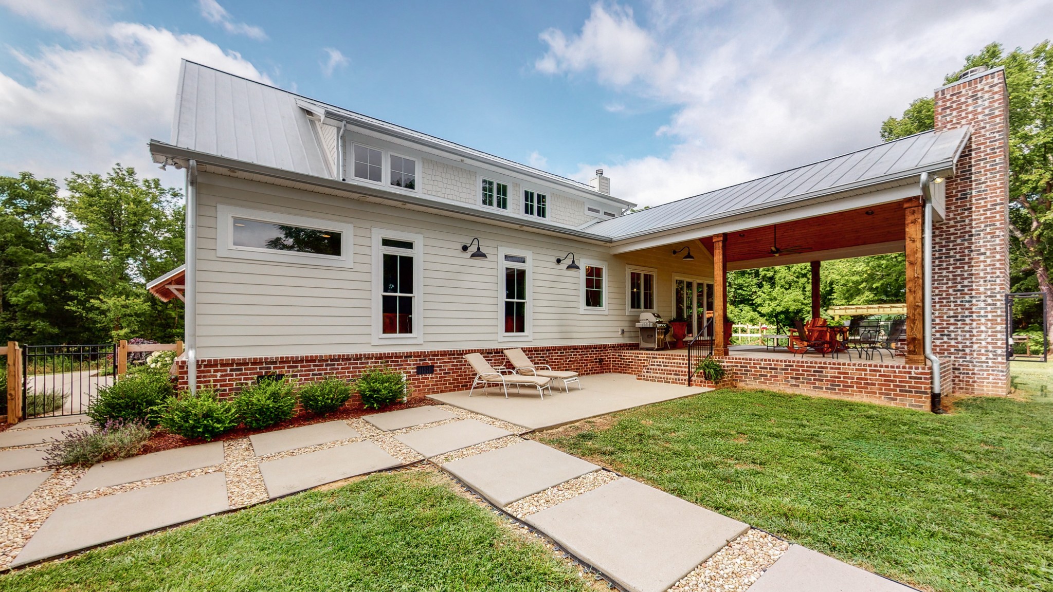 5530 Baker Road Murfreesboro, TN 37129 - Photo 29 of 49 The exterior of the home is Hardie Board Siding atop a brick skirt enclosing the crawl space. This large pathway leads from the parking area, between the second living quarters and the main house, and out to the back yard.