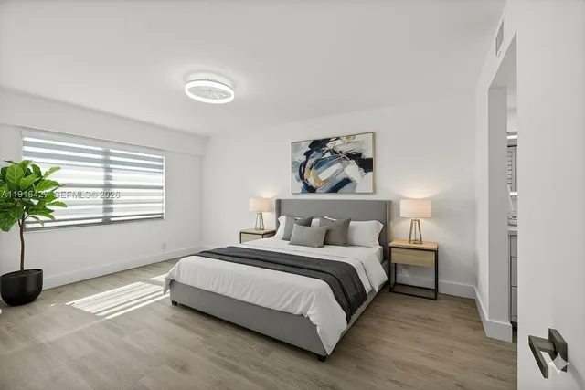 a bedroom with a bed and a potted plant