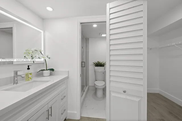 a bathroom with a sink a toilet and shower