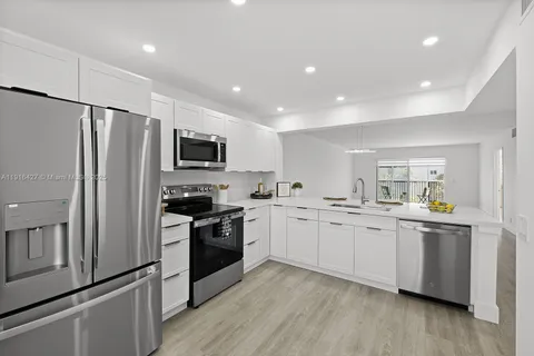 a kitchen with stainless steel appliances granite countertop a refrigerator a stove top oven a sink and dishwasher