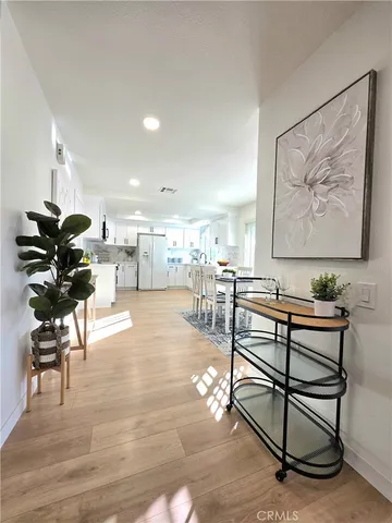 a living room with furniture kitchen view and a potted plant