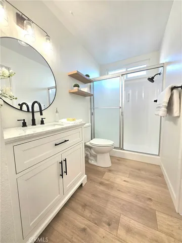 a bathroom with a sink toilet a mirror and shower
