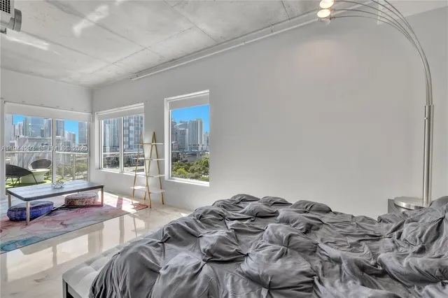 a bedroom with furniture and a large window