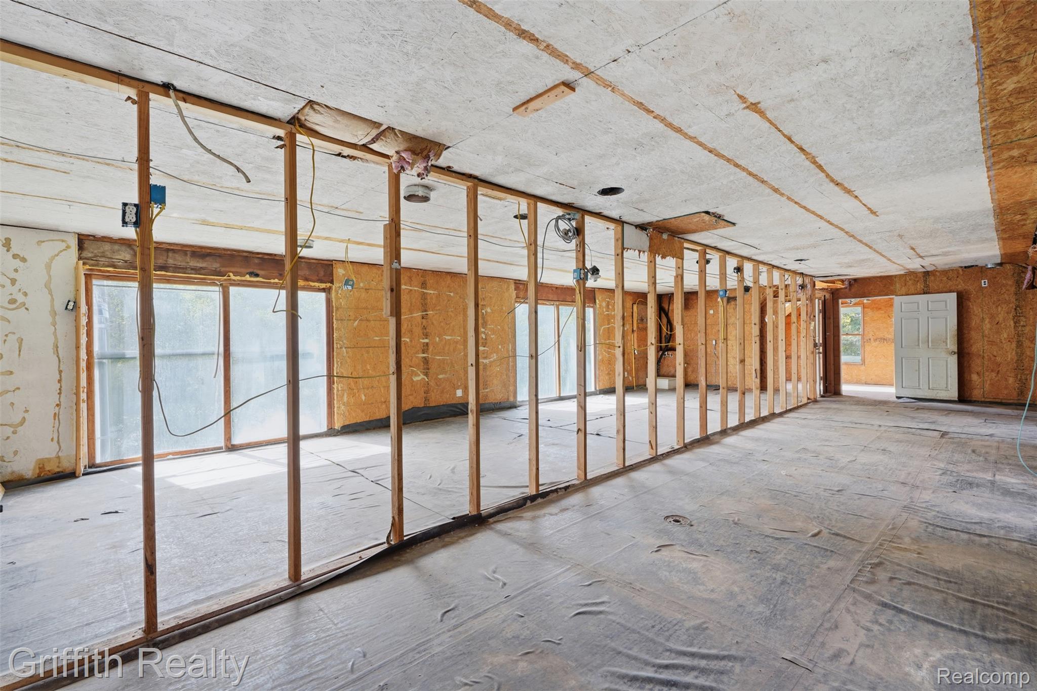 12300 Holtforth Road Fenton, MI 48430 - Photo 27 of 45 Framed interior structure with exposed ceiling, multiple large window openings, and a paneled door