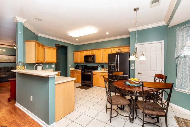 a kitchen with stainless steel appliances kitchen island granite countertop a table chairs sink and window
