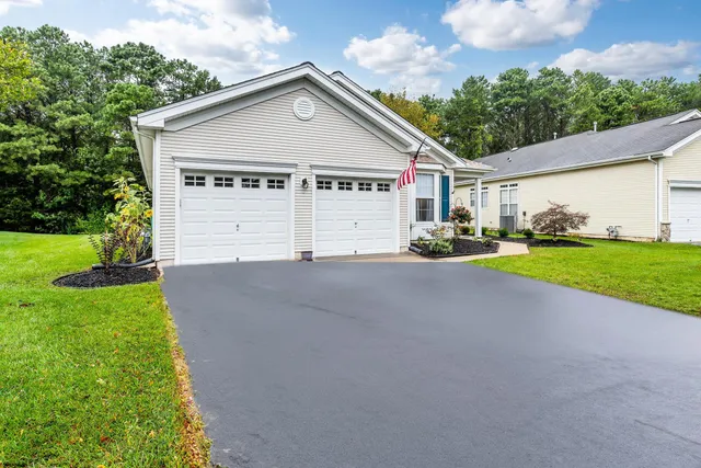 a view of a house with a big yard and large trees