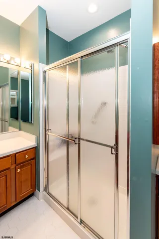 a bathroom with a glass shower door and a sink