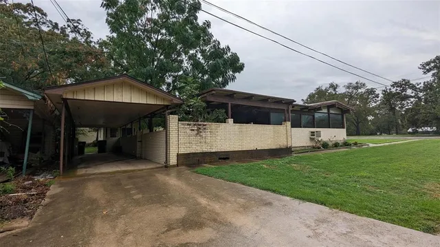 a view of a house with backyard and a tree