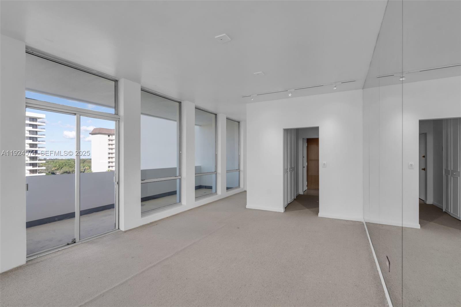 700 Biltmore Way, Unit 710 Coral Gables, FL 33134 - Photo 9 of 41 an empty room with closet and mirrors