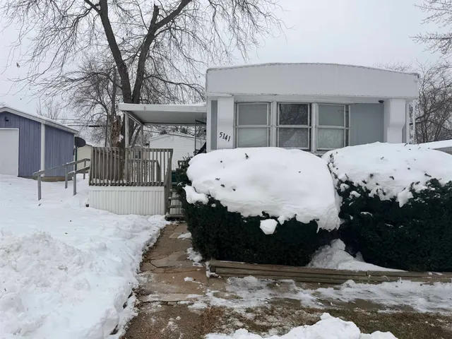 a view of a white house with a large tree
