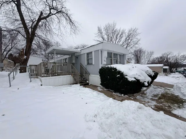 a front view of a house with a yard covered in snow