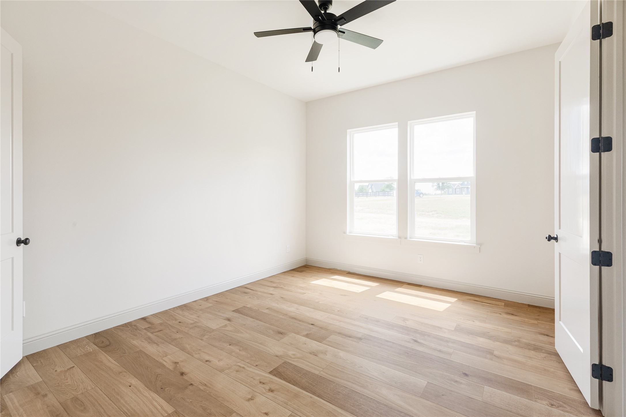 1355 Bluebonnet Ridge Drive Chappell Hill, TX 77426 - Photo 24 of 37 an empty room with wooden floor fan and windows