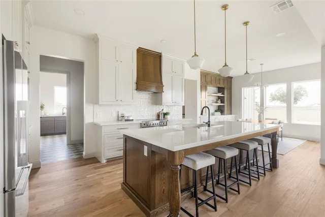 a large kitchen with kitchen island a island a sink stainless steel appliances and cabinets