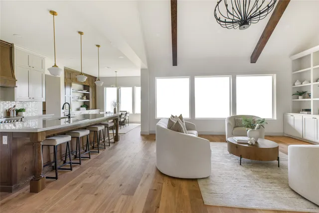 a large living room with furniture wooden floor and a chandelier