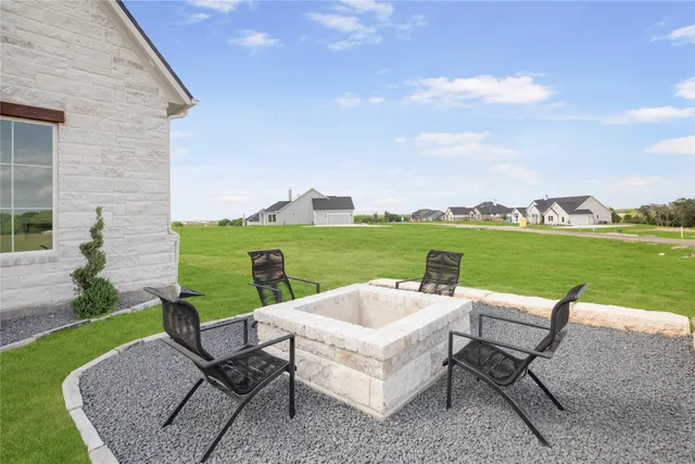 a view of a patio with lawn chairs next to a yard
