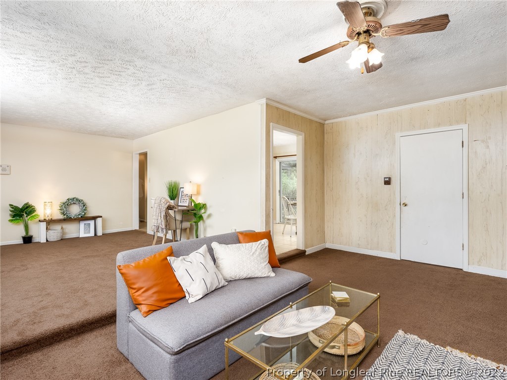7746 Rockfish Road Raeford, NC 28376 - Photo 6 of 26 a living room with furniture and a chandelier