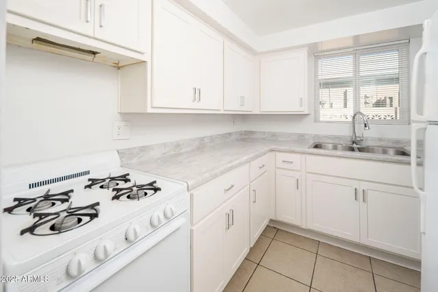 a kitchen with white cabinets and appliances