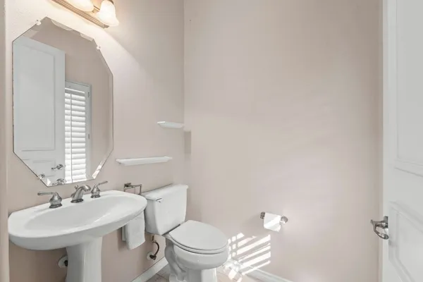 a bathroom with a sink toilet and a mirror