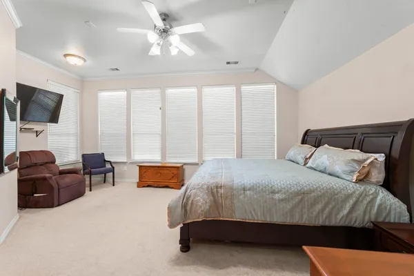 a bedroom with a bed a couch and a flat screen television