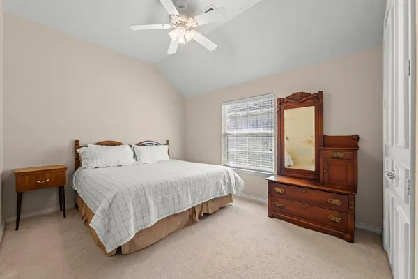 a bedroom with a bed and dresser with cabinet