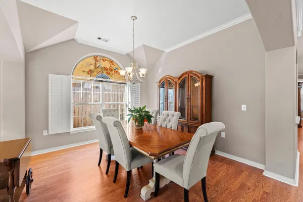 a view of a dining room with furniture a chandelier and wooden floor