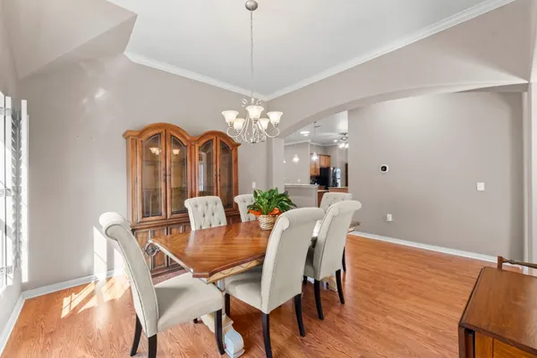a dining room with furniture a chandelier and wooden floor