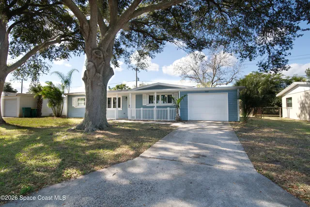 a view of a yard in front of a house with large tree