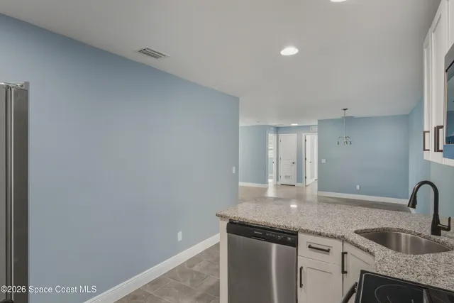 a kitchen with granite countertop a sink and cabinets