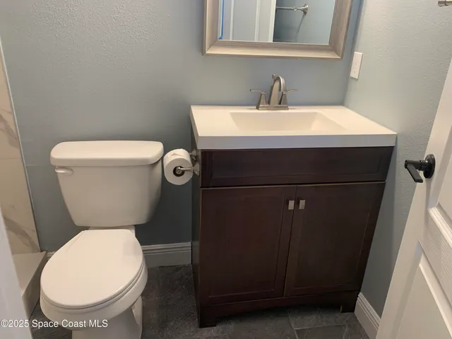 a bathroom with a toilet a sink and a mirror