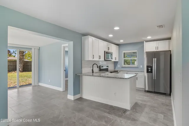 a kitchen with stainless steel appliances granite countertop a refrigerator and a sink