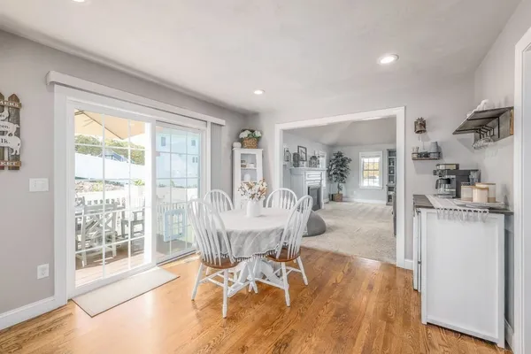 a dining room with wooden floor and a floor to ceiling window