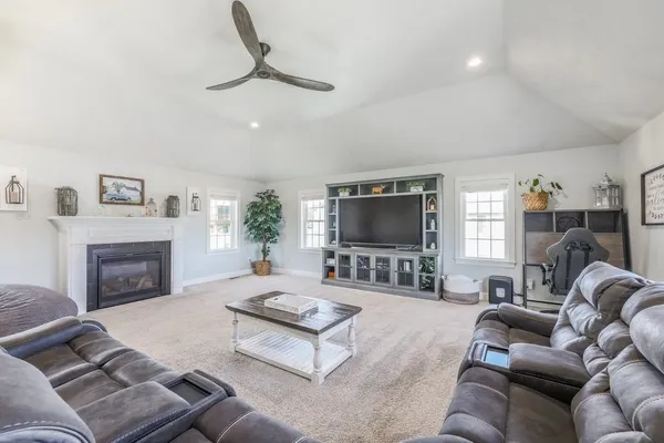 a living room with furniture a flat screen tv and a fireplace