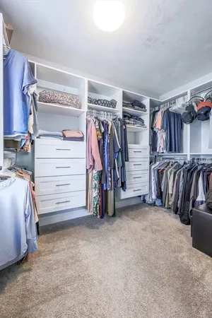 a view of walk in closet with clothes