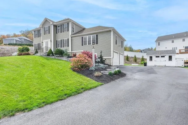 a front view of a house with a garden and yard