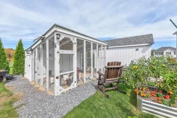 a backyard of a house with a garden and barbeque oven