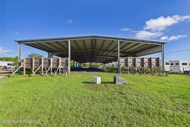 a view of a backyard with table and chairs under an umbrella