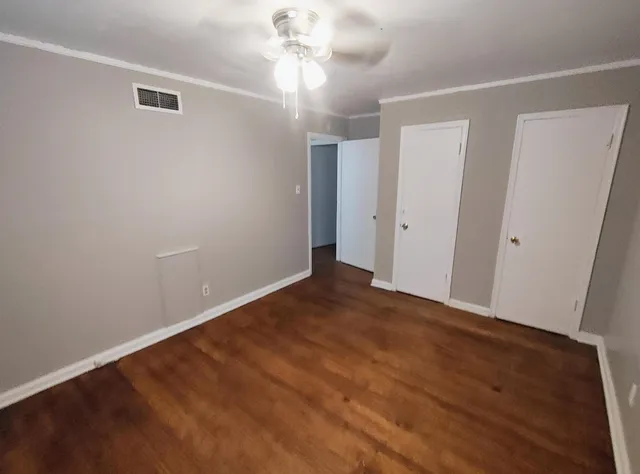 a view of an empty room with wooden floor