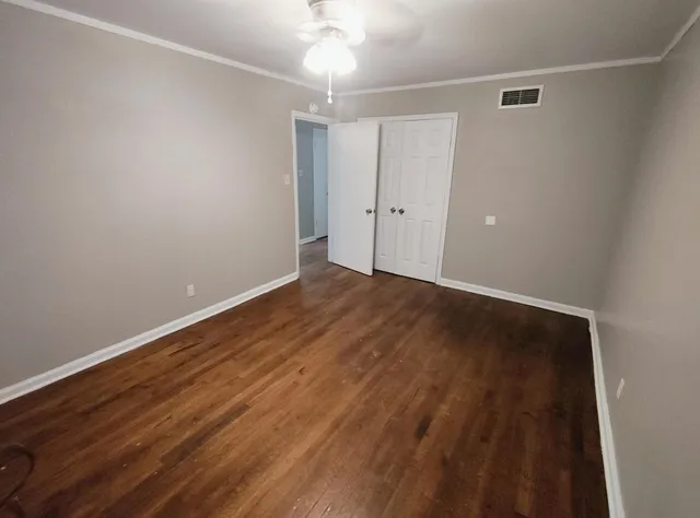 a view of an empty room with wooden floor