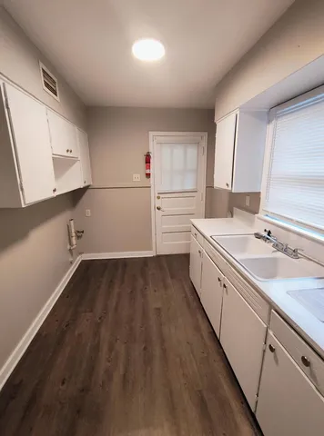 a view of a kitchen with wooden floor and electronic appliances