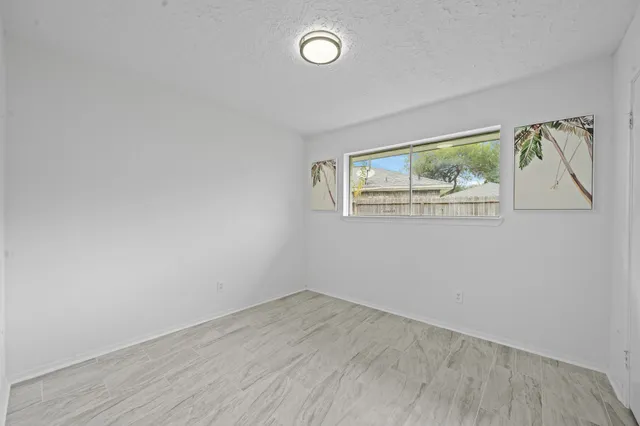 an empty room with wooden floor and window