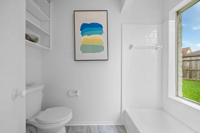 a bathroom with a toilet and a shower