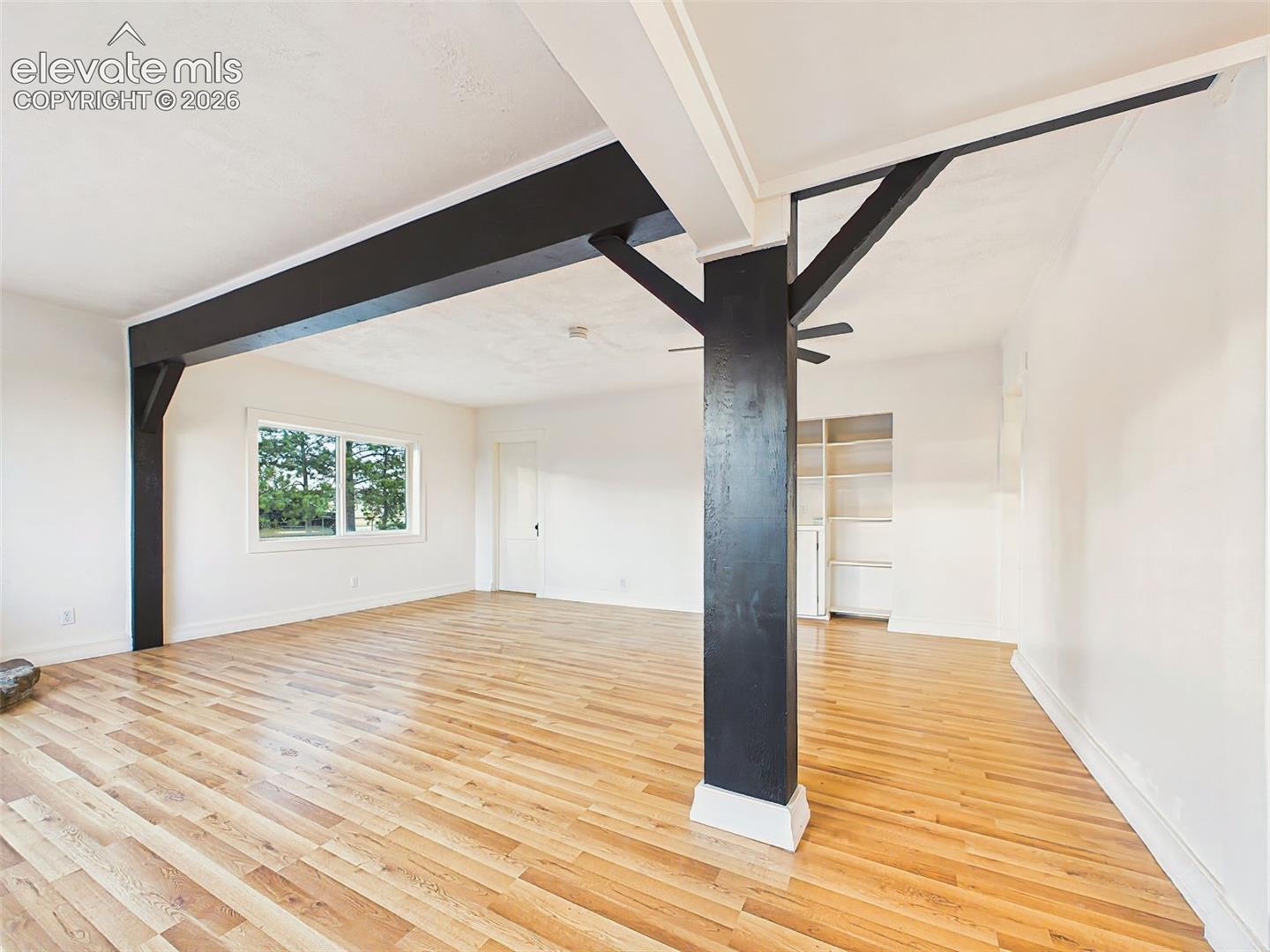 Great Room – Architectural beam details add character to this bright, open gathering space filled with natural light from oversized windows.
