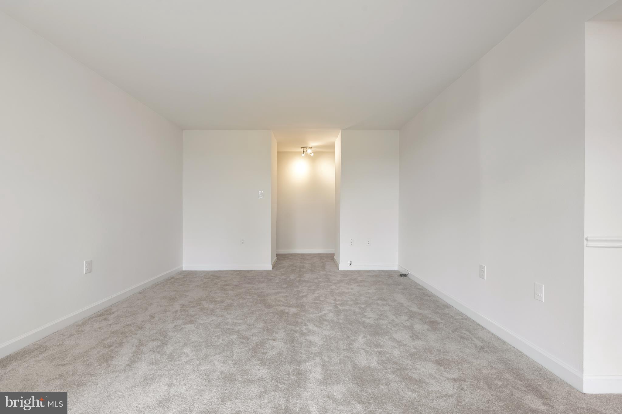 18715 Walkers Choice Road, Unit 18715 Montgomery Village, MD 20886 - Photo 4 of 30 a view of an empty room with yellow lighting