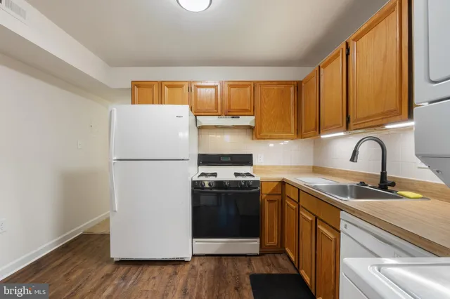 a kitchen with a sink a refrigerator and cabinets